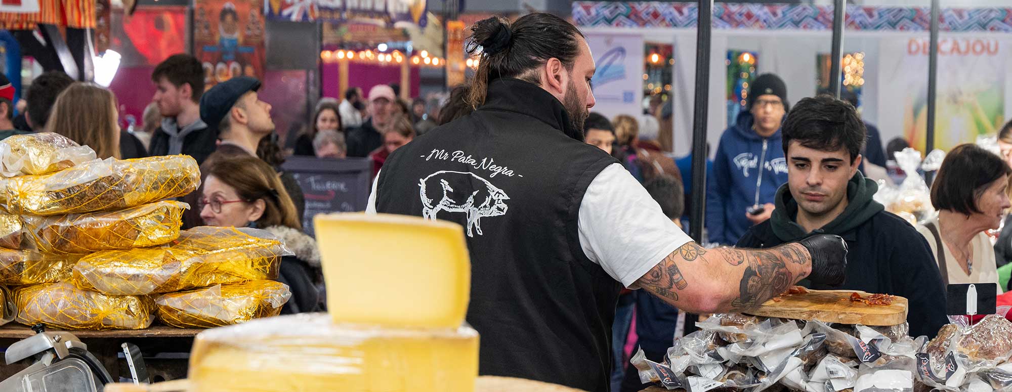 Exposant sur un stand de fromage et de charcuterie