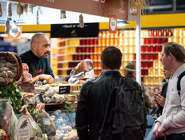 Exhibitor behind his delicatessen stand